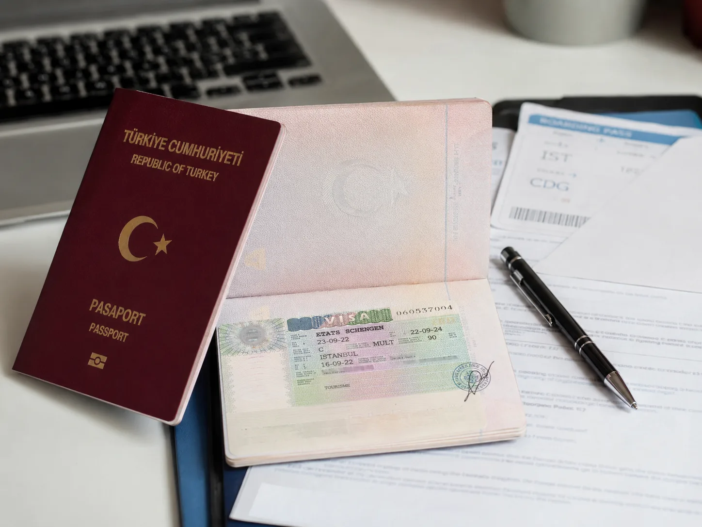 Schengen vizesi başvurusu için pasaport, vize sayfası, uçak bileti ve başvuru evrakları.