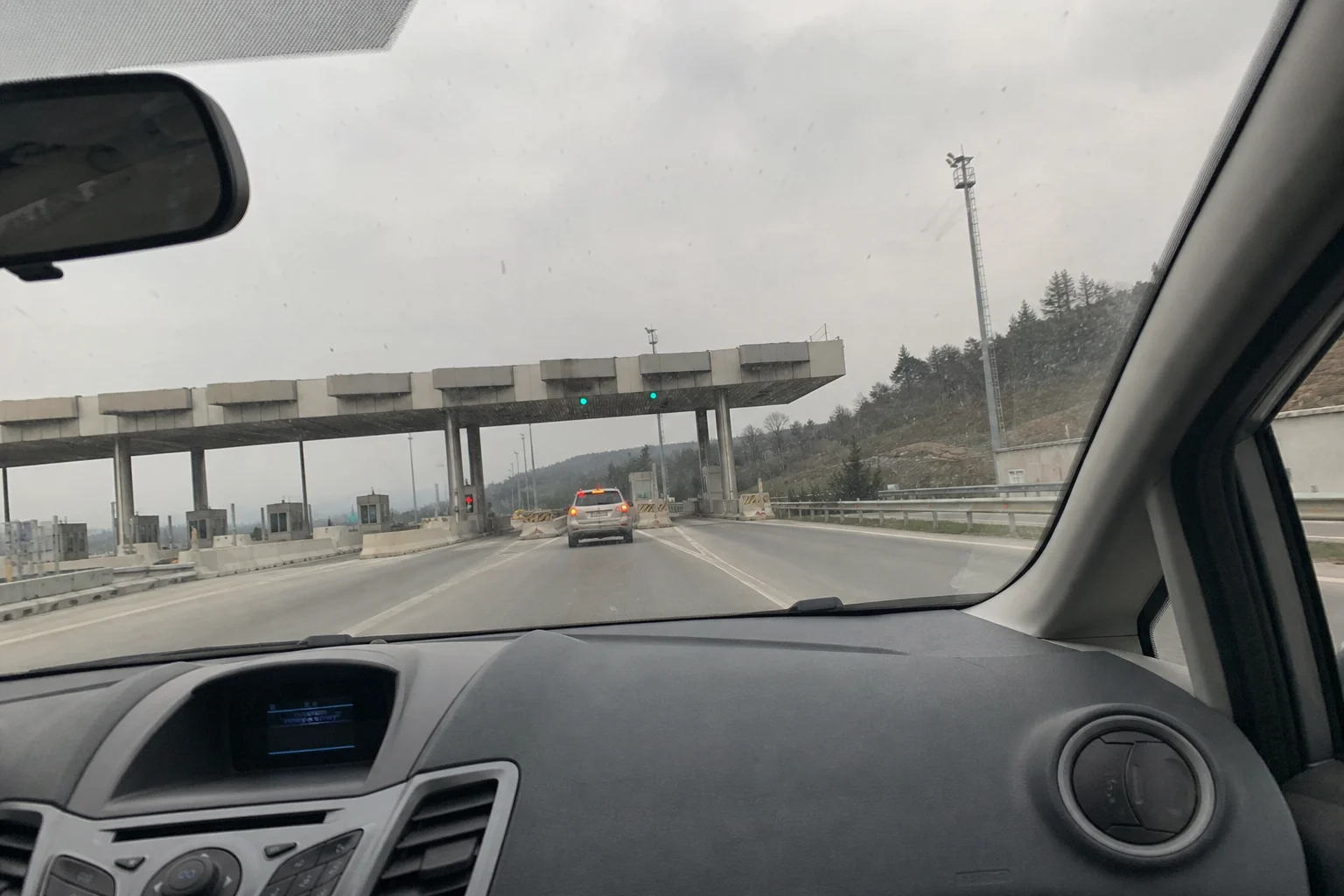 Araç içerisinden görüntülenen otoyol geçiş noktası ve gişeler; **HGS borcu** sorgulama ve otoyol geçiş ücretlerini temsil eden yol manzarası.