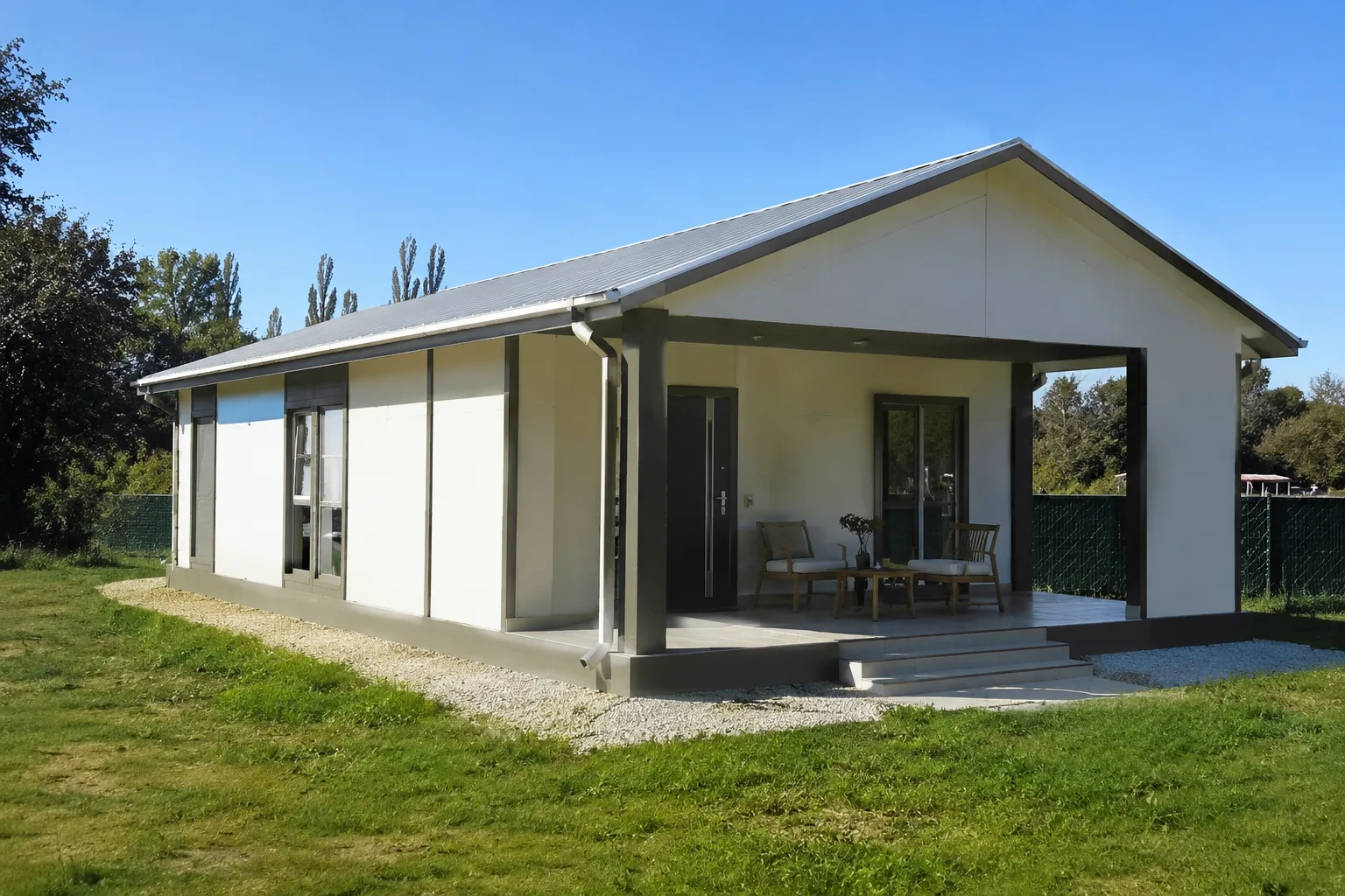 Bahçeli alanda bulunan, verandaya ve eğimli çatıya sahip tek katlı prefabrik ev – prefabrik(konteyner) DASK.